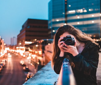 woman using black camera outdoors