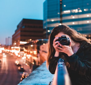 woman using black camera outdoors