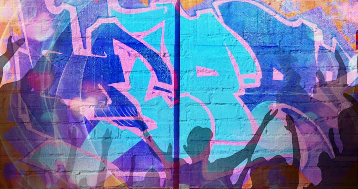 Vibrant street art covers a brick wall with intertwining letters and shapes in shades of blue and purple. Silhouettes of people with raised arms overlay the graffiti, suggesting a lively, energetic atmosphere.
