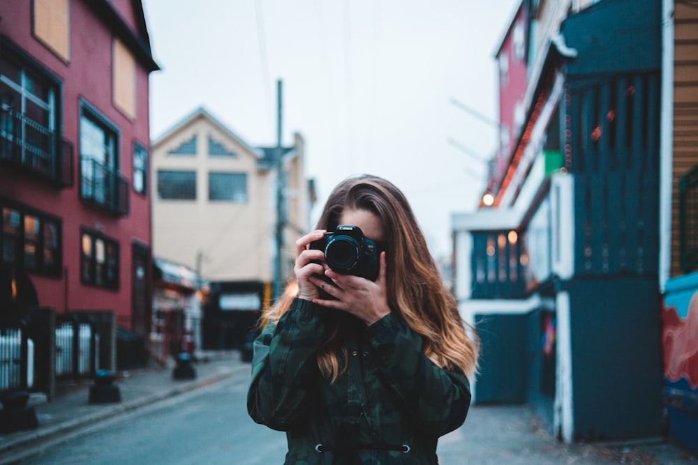 woman taking photo using DSLR camera