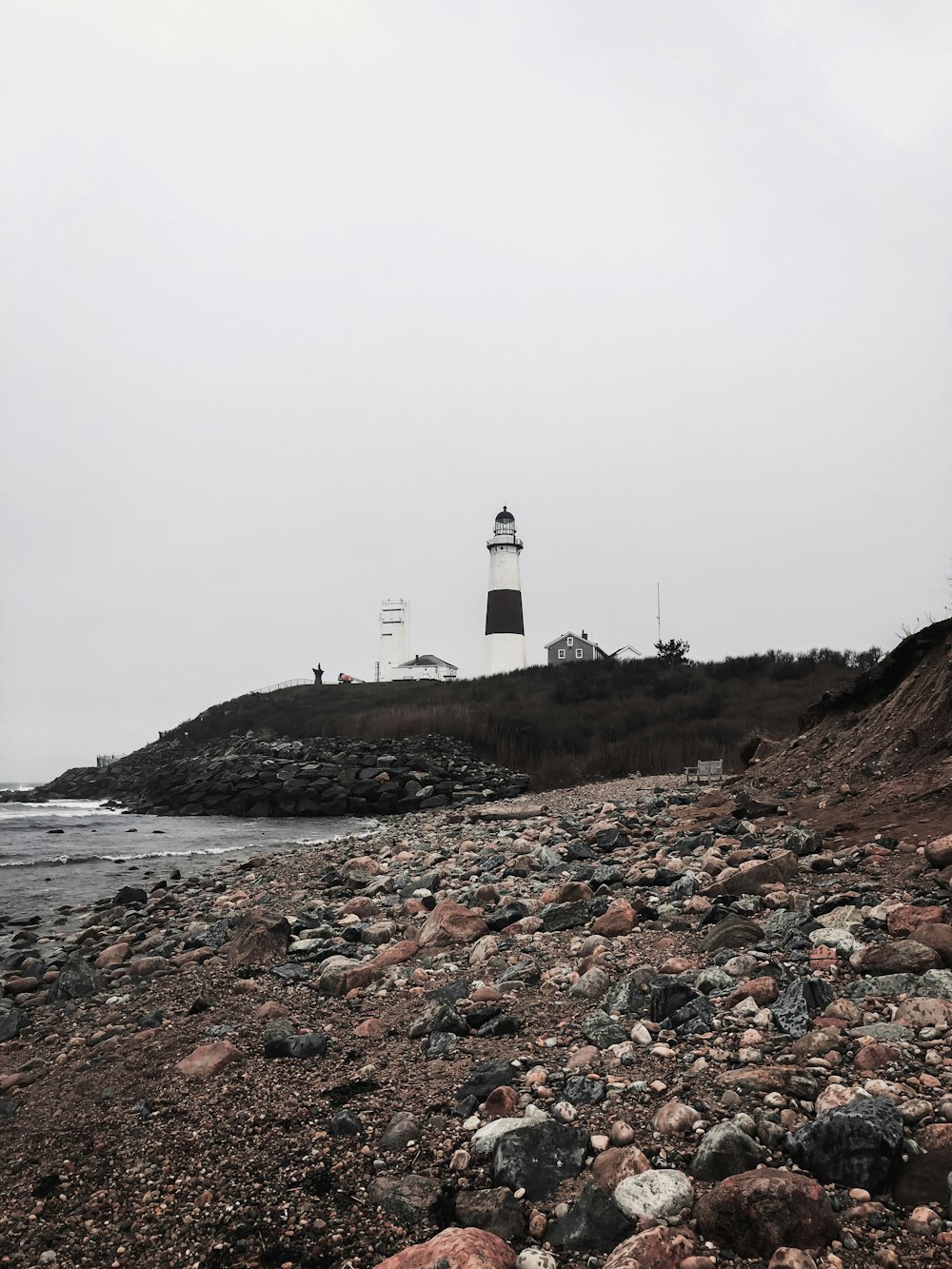 lighthouse atop of hill by sea