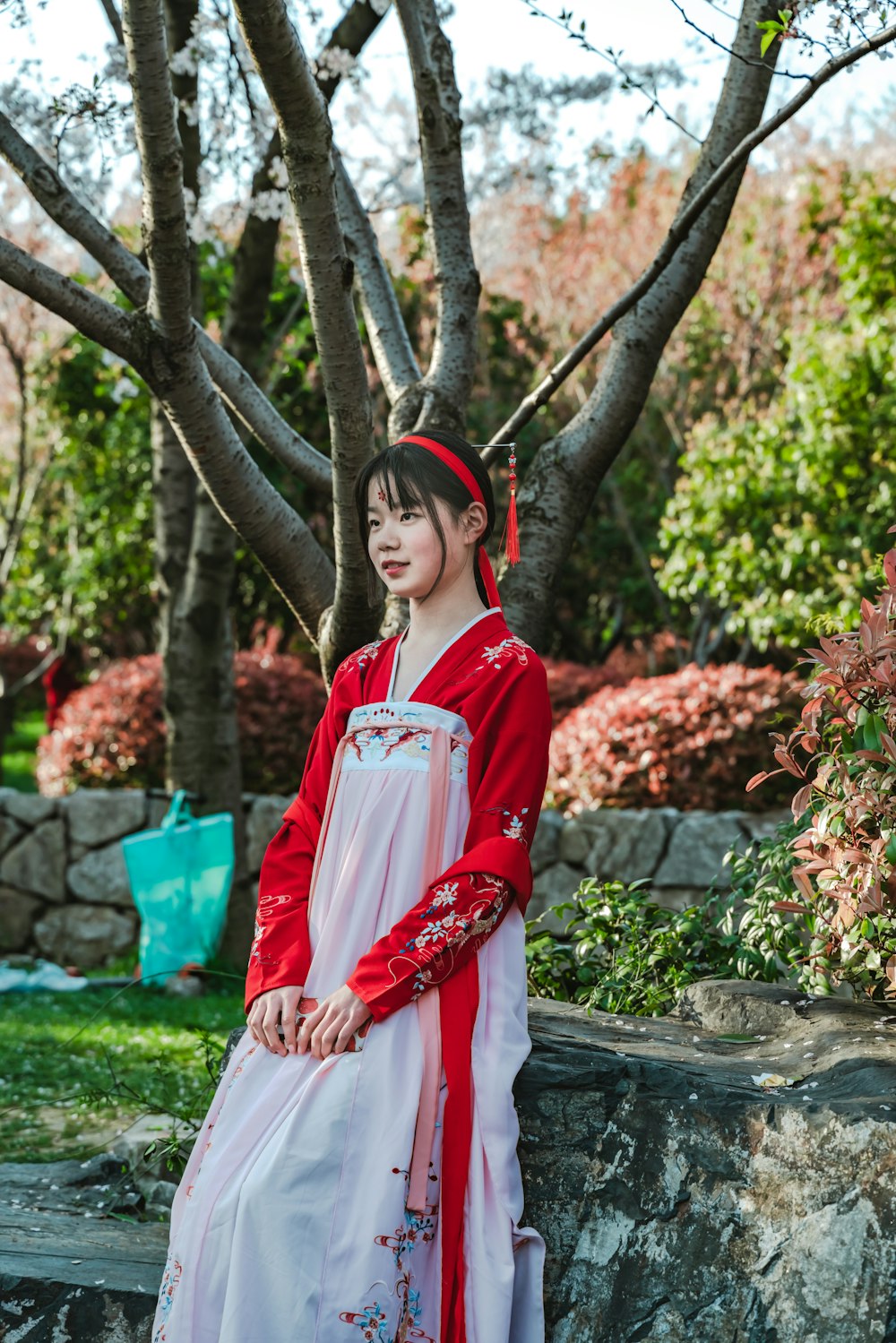 woman wearing white and red dress standing near trees during daytime