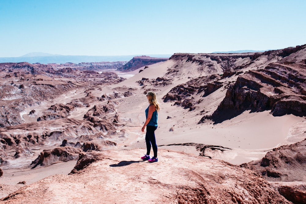 woman wearing blue tank top on cliff