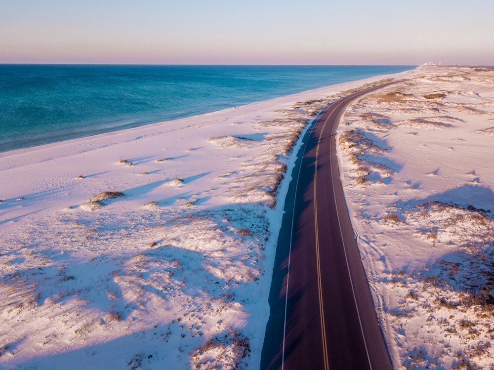 Vista de pájaro de la carretera entre la hierba cubierta de nieve