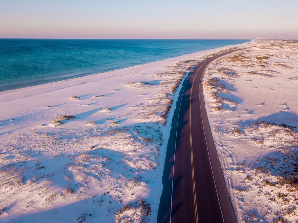 bird's eye view of road between snow covered grass