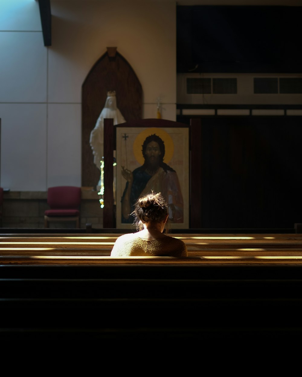 woman sitting on church pew during daytime