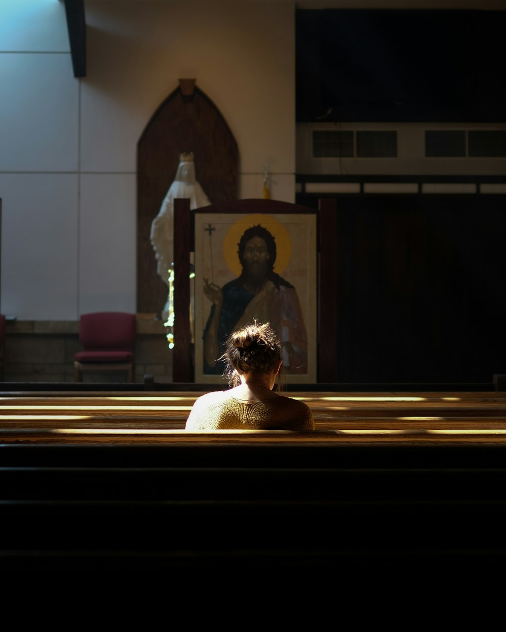 femme assise sur le banc de l’église pendant la journée