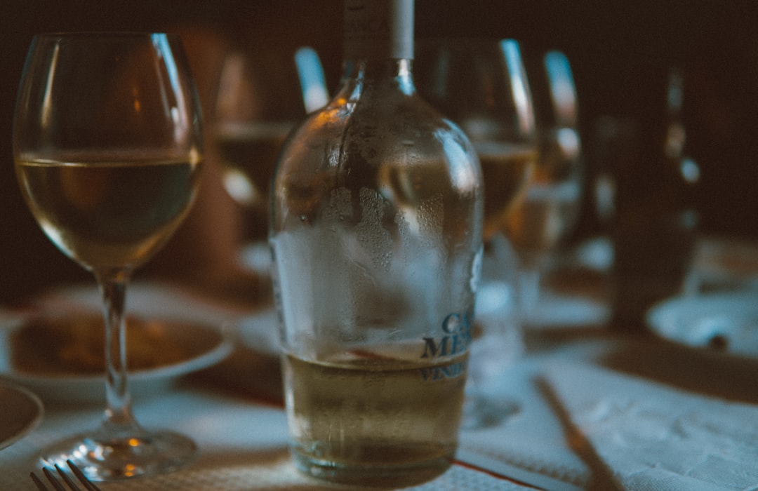 half-filled liquor bottle on wine glasses