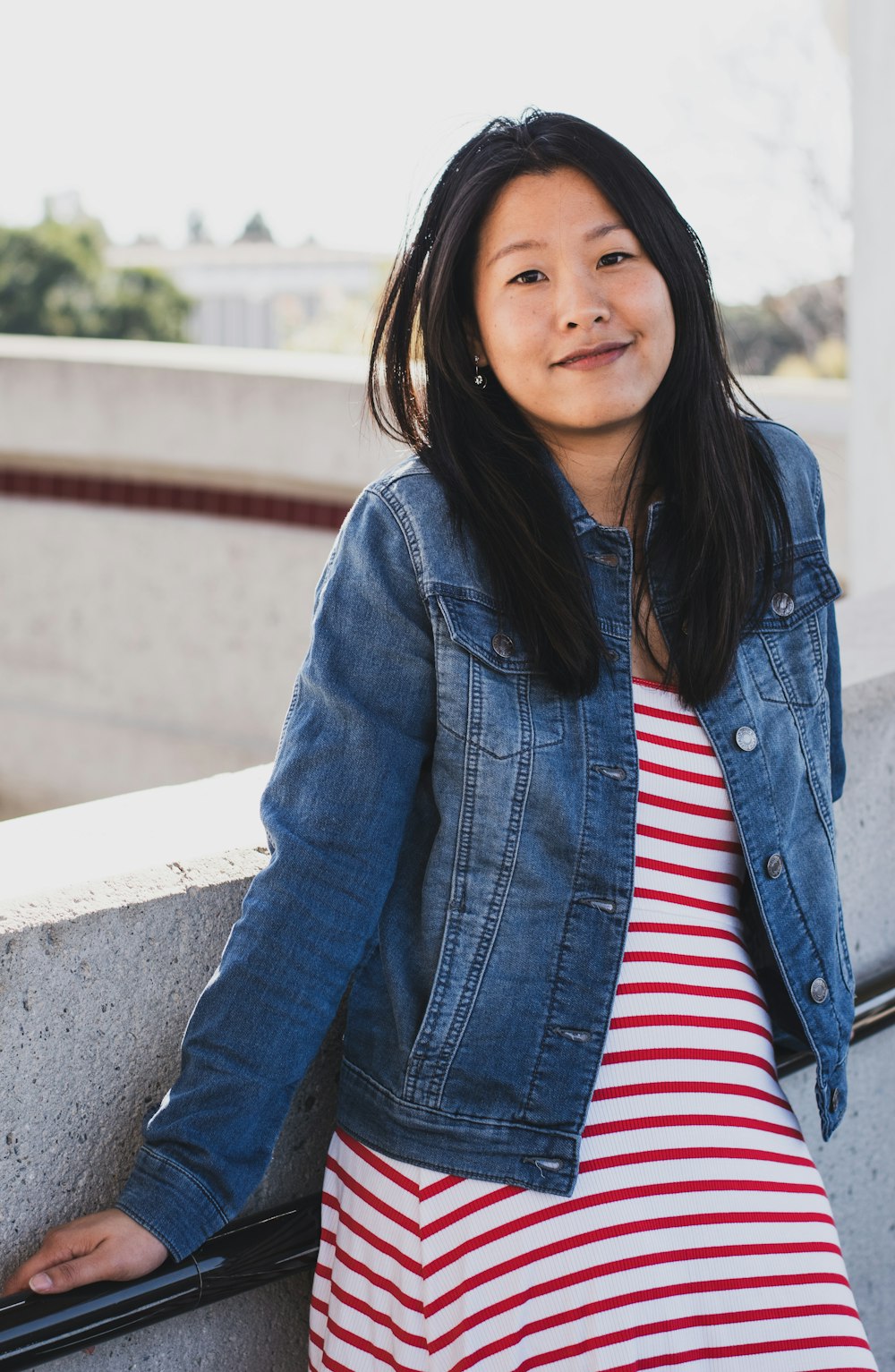 smiling woman in blue jacket leaning on rail