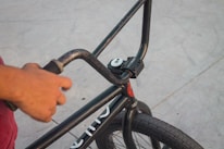 A close-up of a child's hand gripping a non-slip bike handlebar.