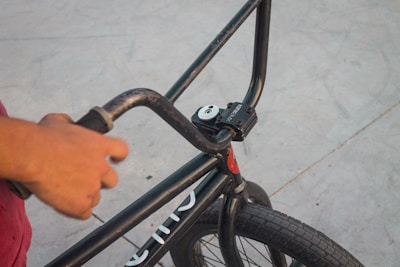 Close-up of a child’s hands gripping a bike handlebar, ready to take off on a trail.