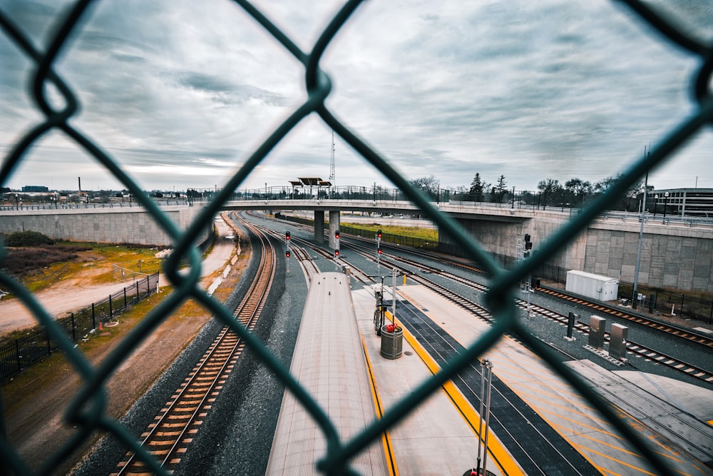 a view of a train track through a fence