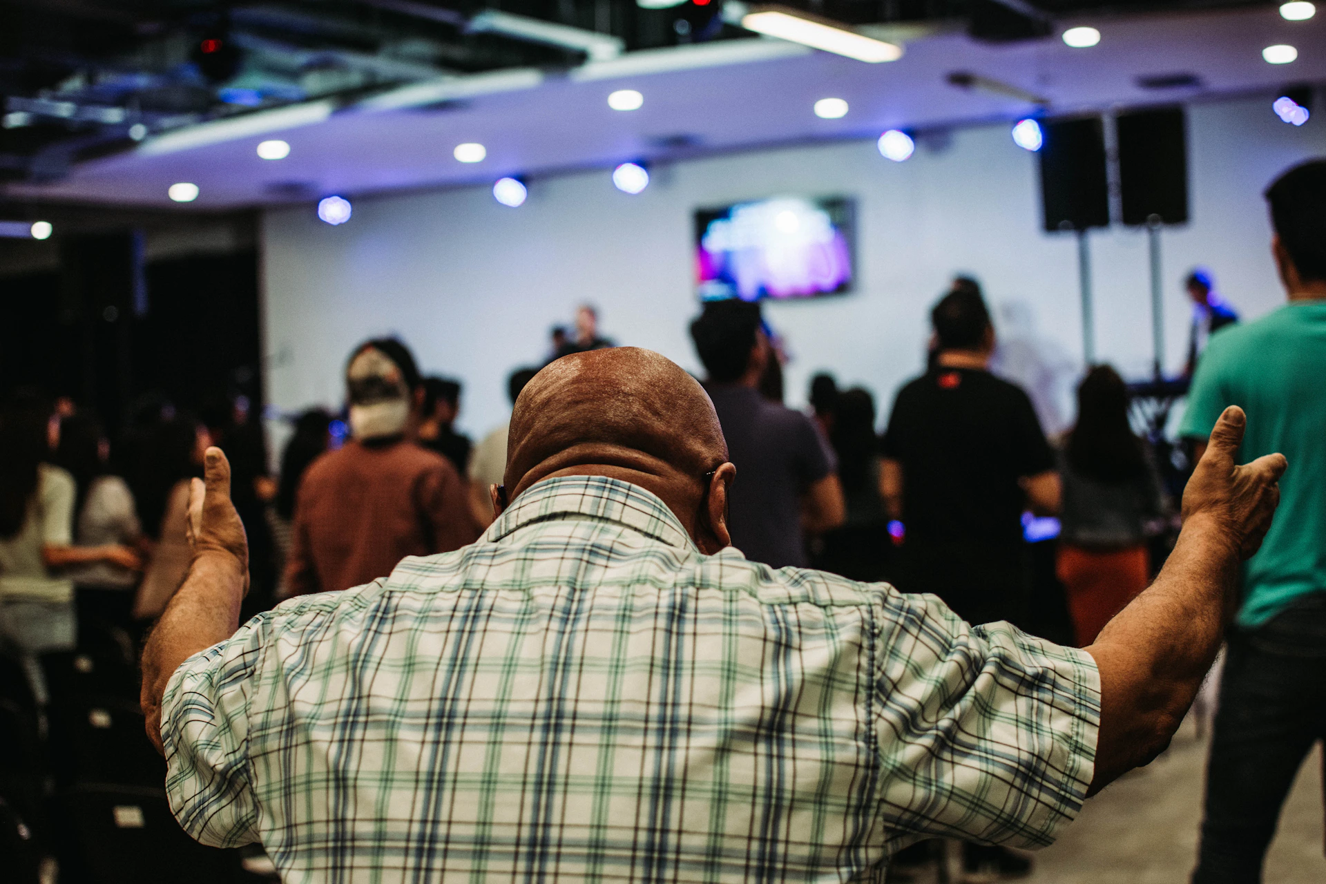 A heartfelt photo of Dewit Anderson speaking passionately at a community church event in Kinston, with warm lighting capturing the crowd’s engaged faces.
