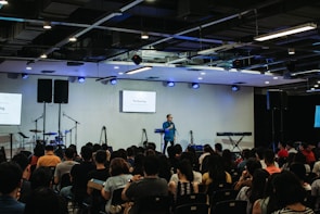 Close-up of a speaker explaining advanced treatment techniques on stage.