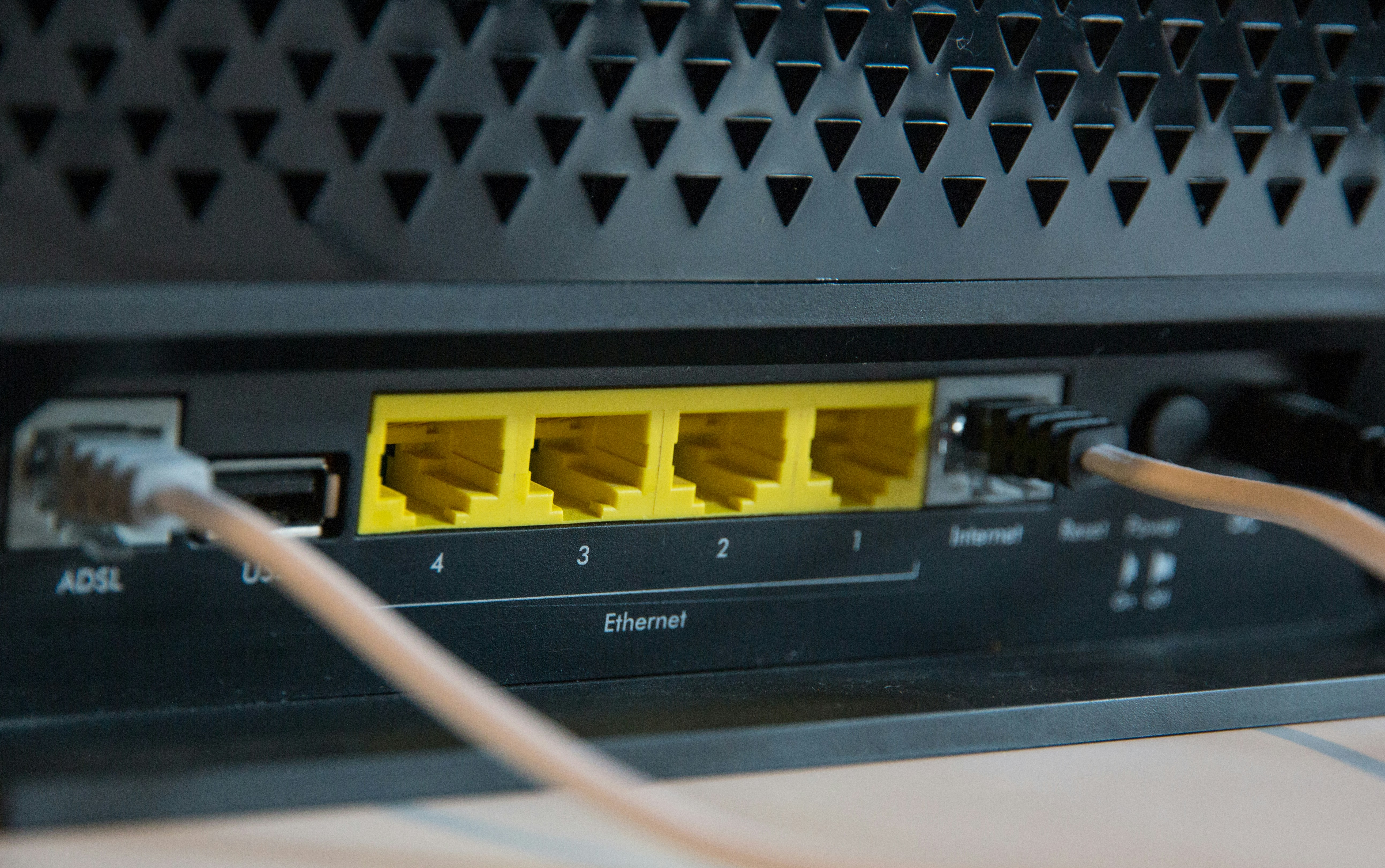 Image of the back of an internet router with ethernet jacks. Photo by Stephen Phillips on Unsplash