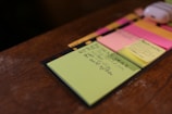 green sticky note on brown surface