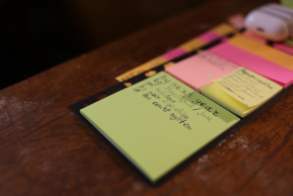 green sticky note on brown surface