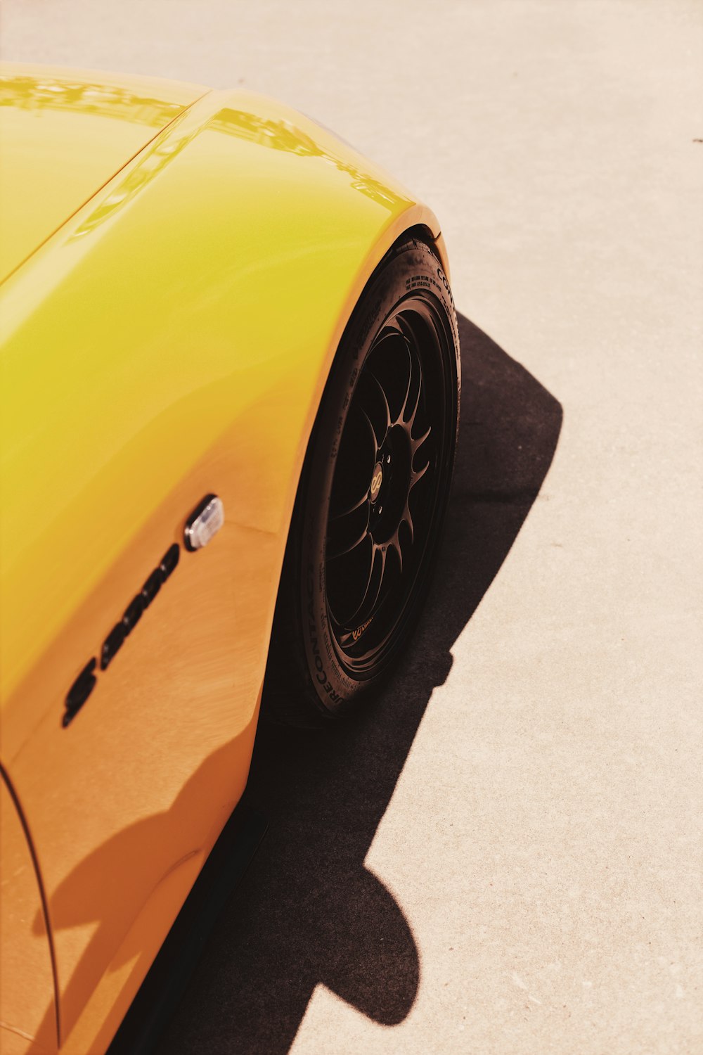 yellow vehicle on gray pavement