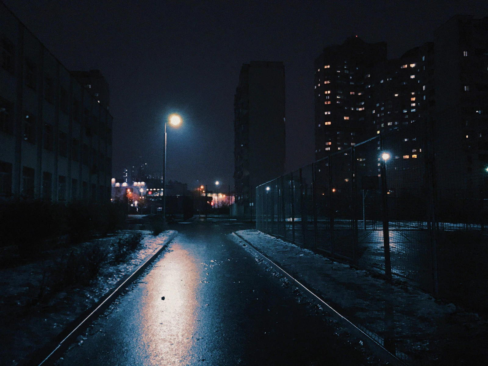 A wet road at night lit by street lighting