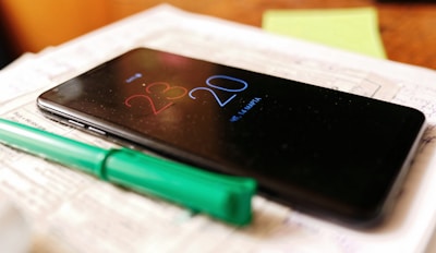 A business owner checking messages on a smartphone late at night.