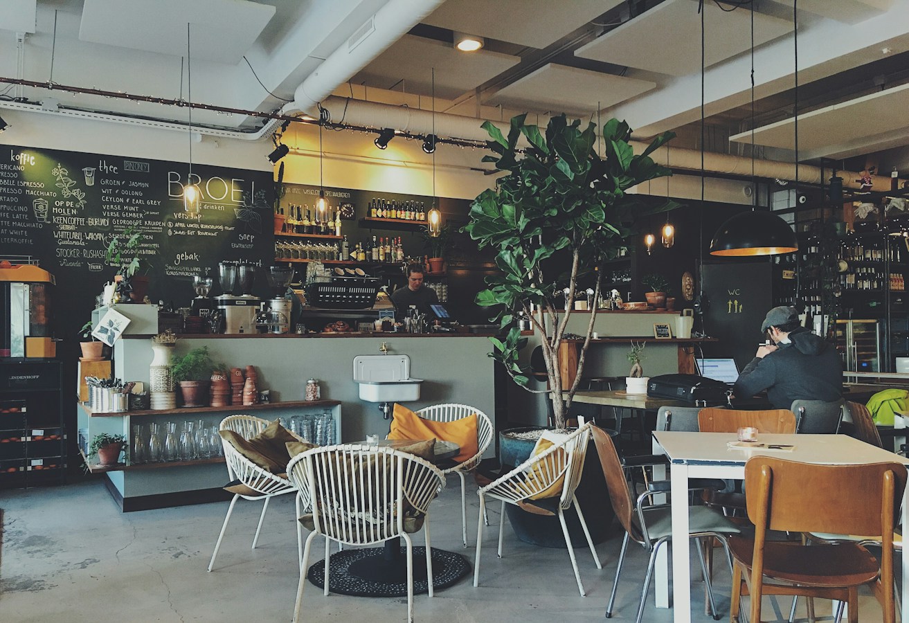 Interiér Kreative Café s útulným posezením a teplým světlem
