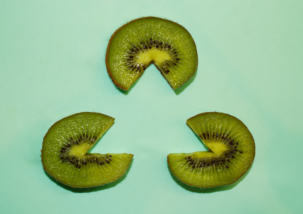three sliced kiwi fruits forming triangle shape