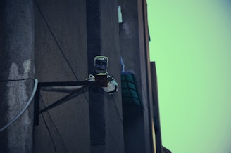 Technician setting up surveillance cameras on a commercial building exterior.