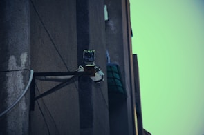 Outdoor surveillance camera mounted on a building corner at dusk.