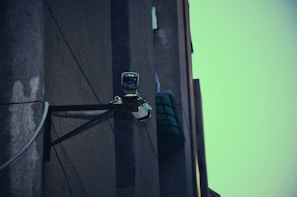 A technician installing a surveillance camera on a building.