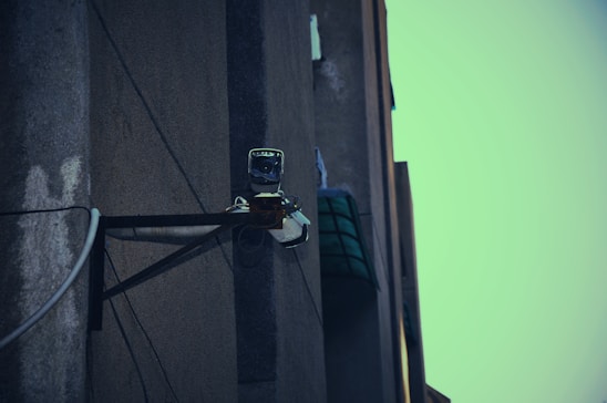 A technician installing a CCTV camera on a commercial building.