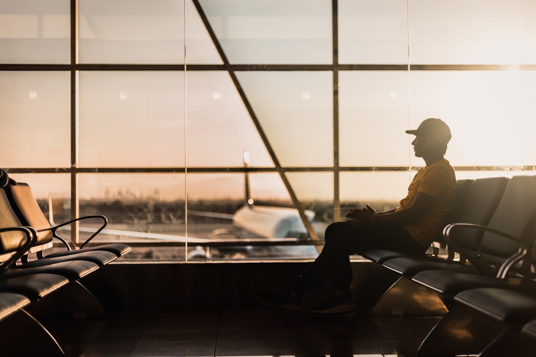 man sitting on gang chair near window, Waiting