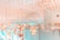 An elegant room with a ceiling adorned with numerous hanging golden floral ornaments. The space has a modern, luxurious design with glass walls and soft lighting. Chairs and tables can be seen in the background, contributing to a sophisticated and inviting atmosphere.
