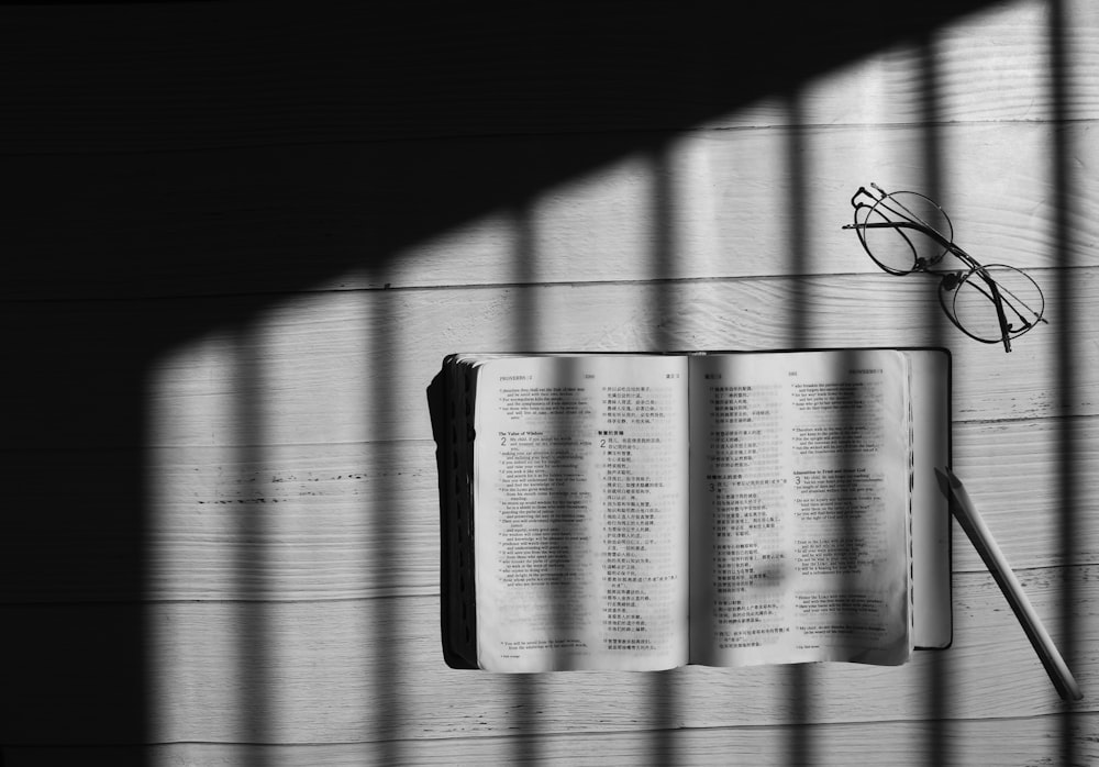 flat lay photography of an eyeglasses beside open book