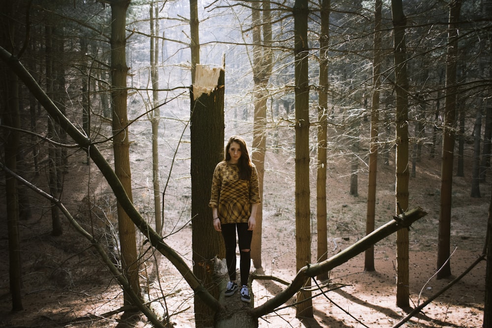 woman standing on tree trunk