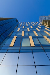 low-angle photography of blue glass building
