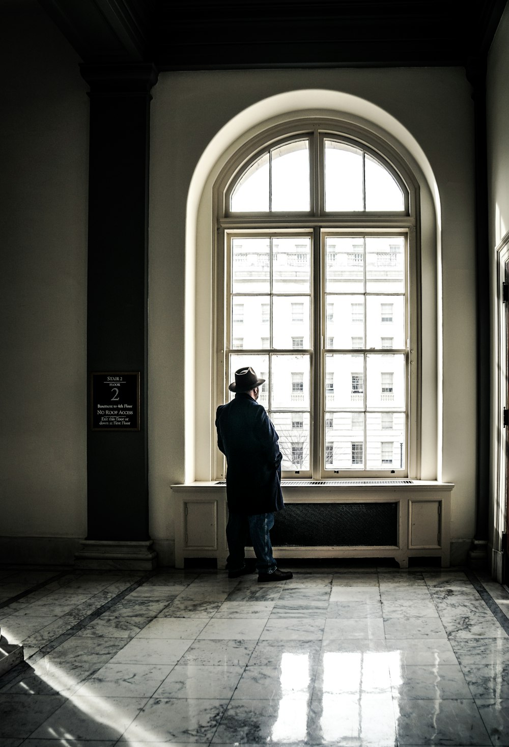 man standing in front of window during daytime