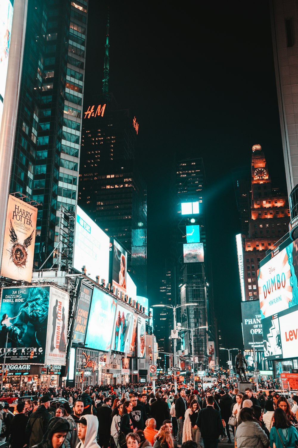 crowd walking between buildings with e-billboard during night