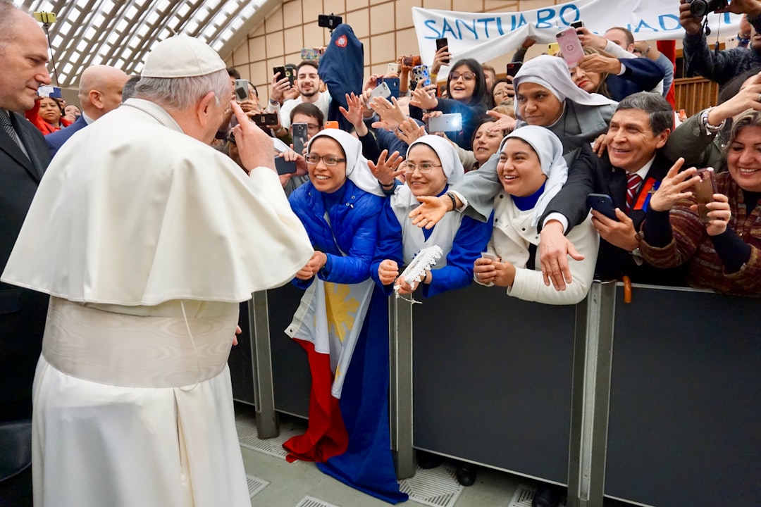 Pope Francis standing surrounded with people