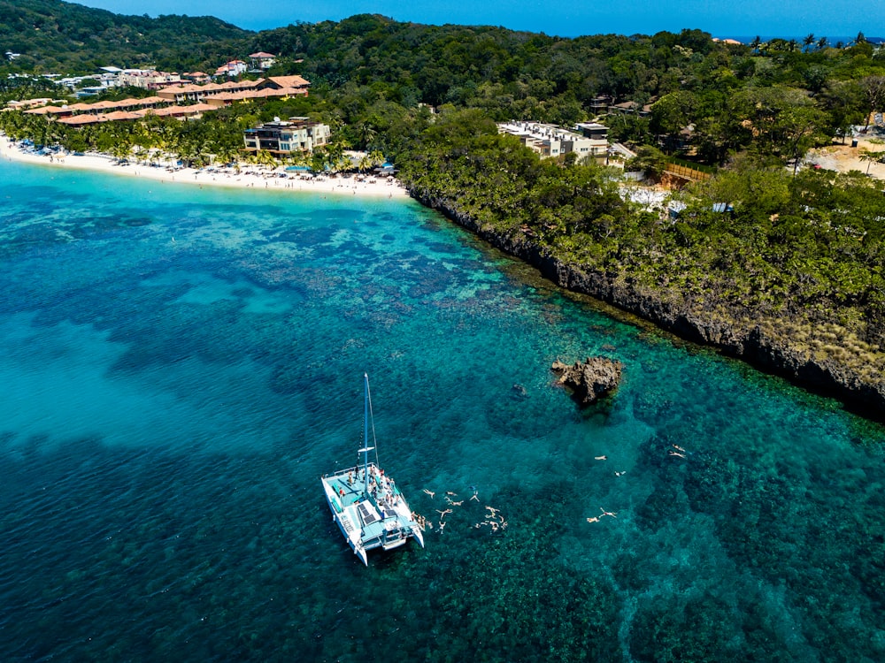 motorboat on body of water near island in aerial photography