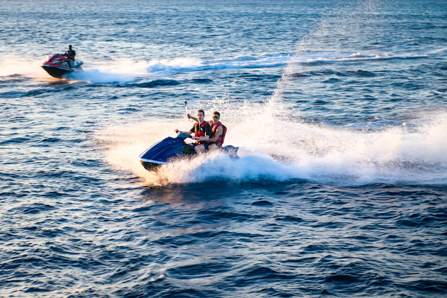Two riders sharing a jet ski, throwing spray as they turn