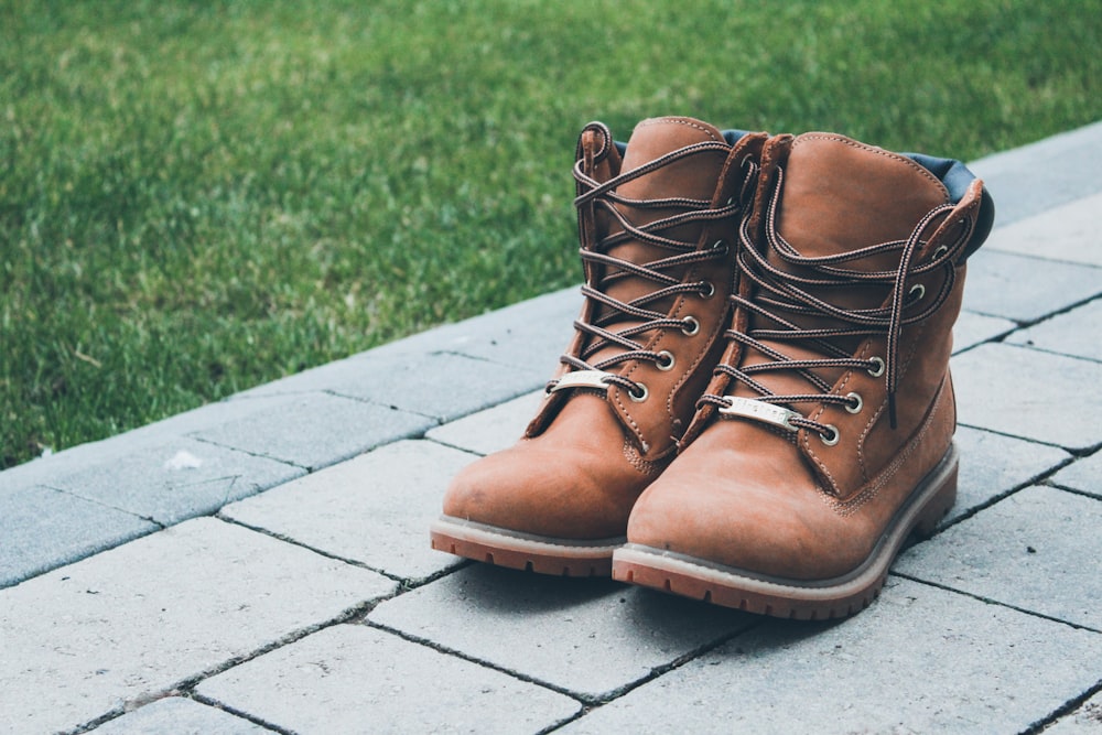 pair of brown boots on brick road near grass