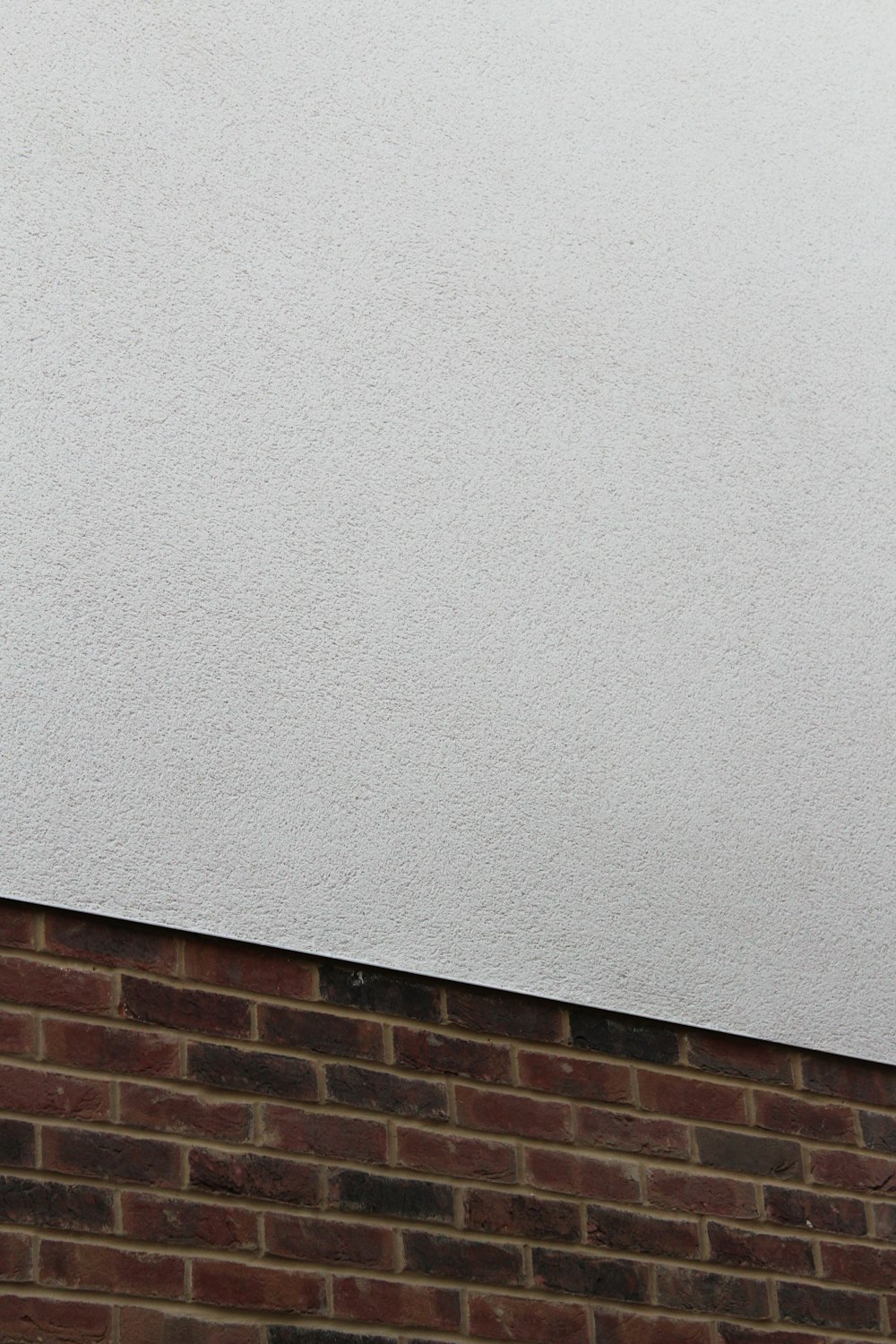 red brick wall and plain white concrete wall