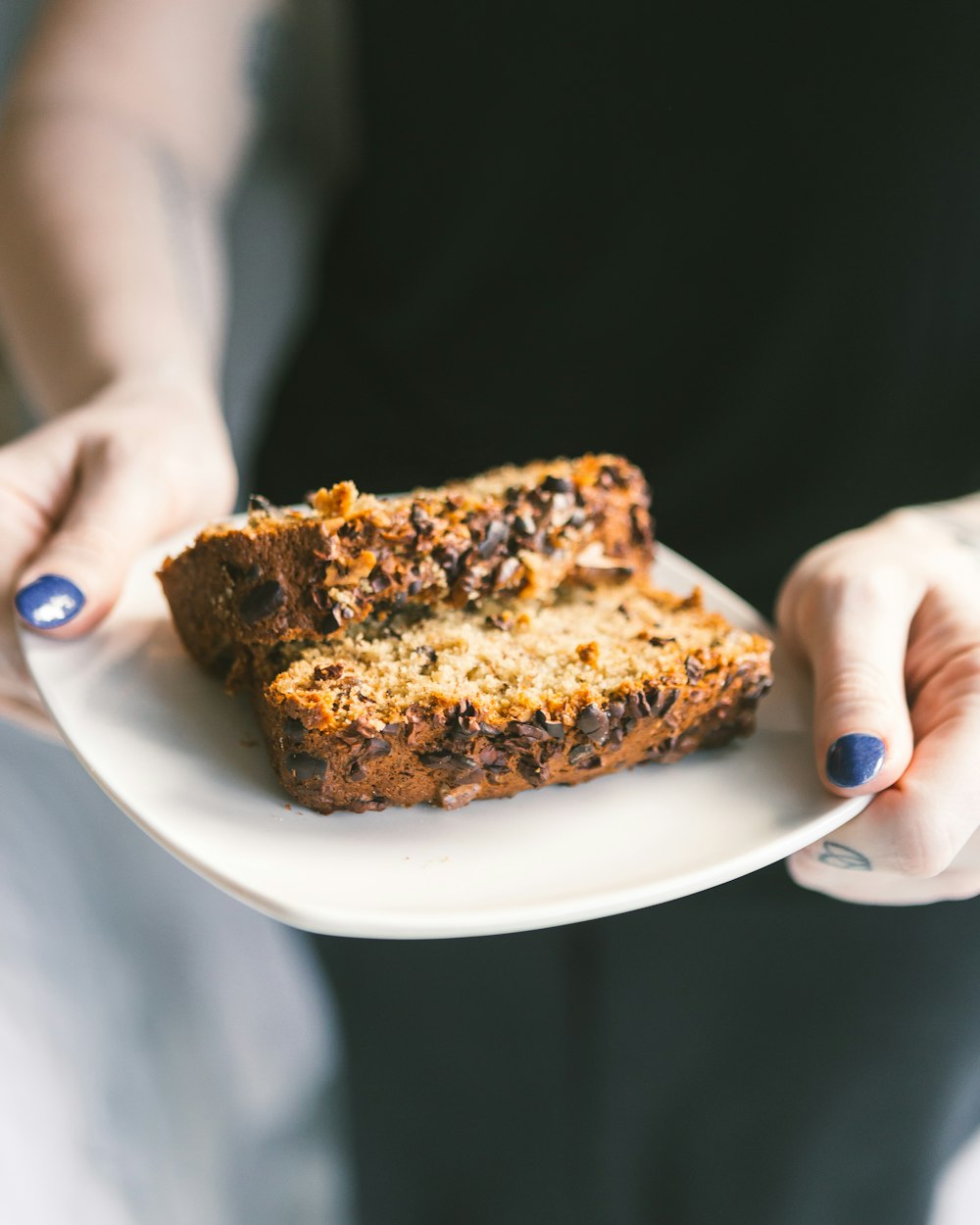 person holding baked bread on a saucer