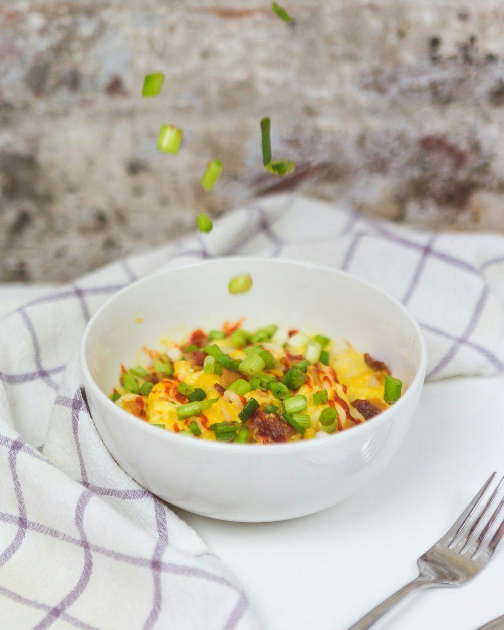 cooked egg with spring onions in a bowl