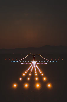 Nighttime airfield lighting casting a soft glow around a quiet runway.