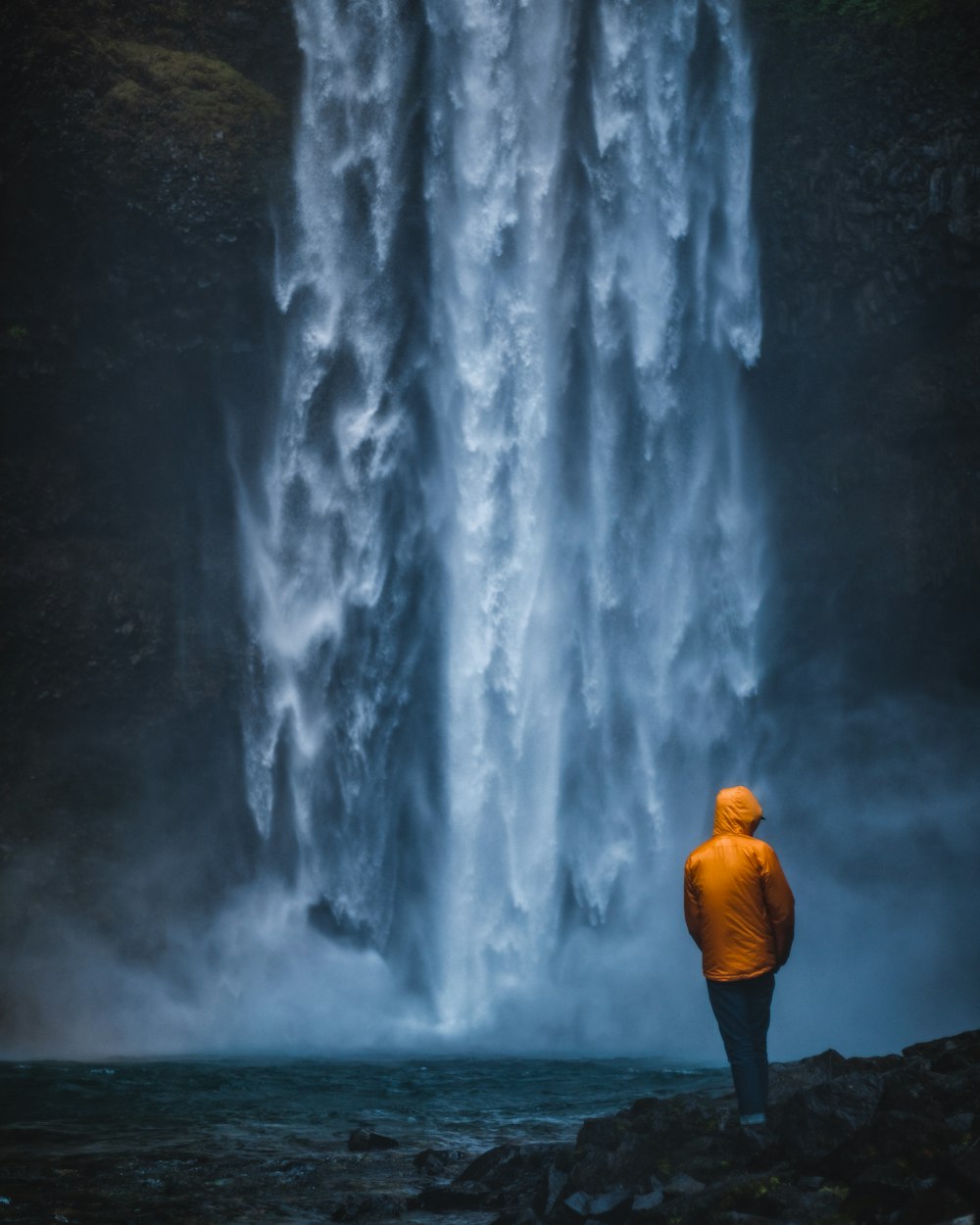 man standing near waterfalls