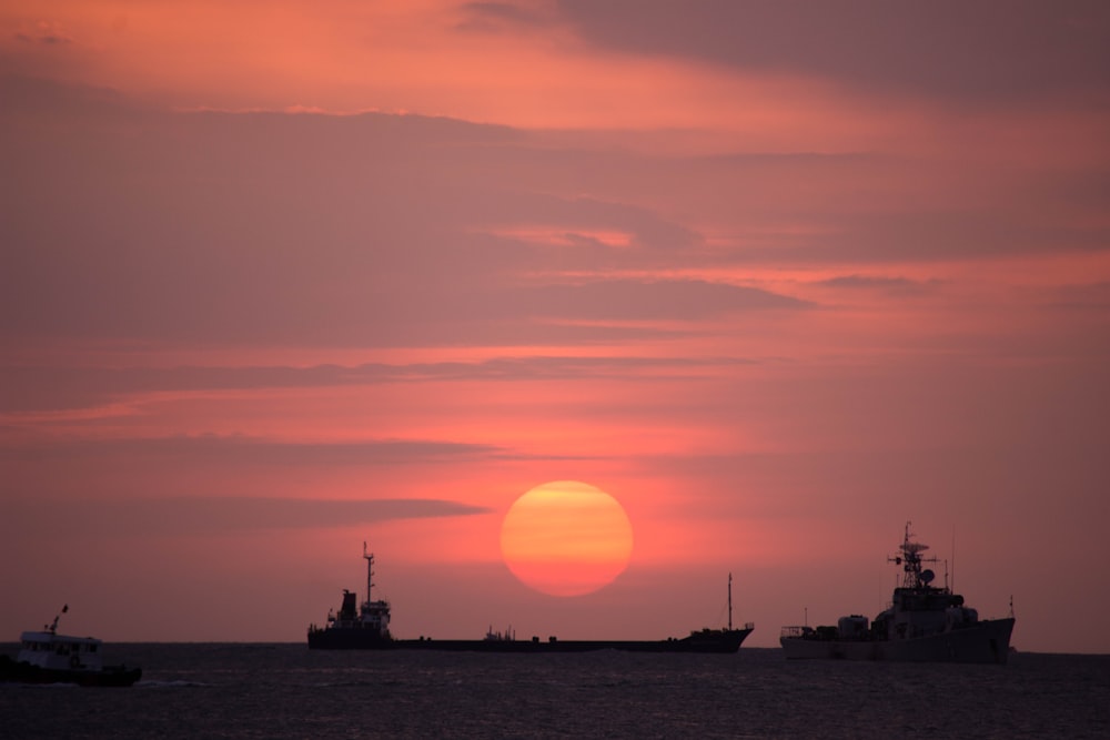 três navios durante o pôr do sol