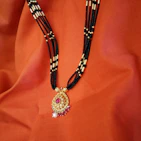 A beautifully arranged gift set featuring a necklace, tasbih beads, and a small oud bottle.