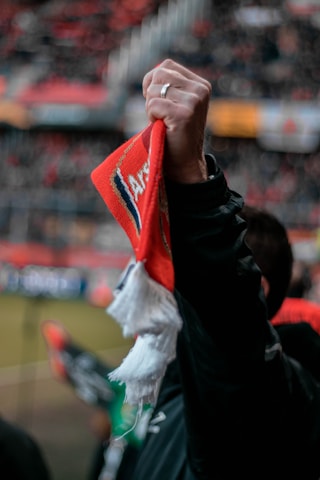 Close-up of rally towels and stickers featuring bold team logos waving proudly at a game.