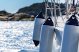 Close-up of a sleek turquoise boat fender hanging on a wooden dock at sunset.